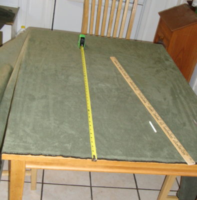 Laying out fabric on the kitchen table, to cut and sew for the couch throw and cushion covers.