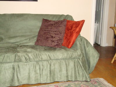 50 cent couch covered in beautiful throw I sewed with pillows I covered with excess fabric from the recliners.